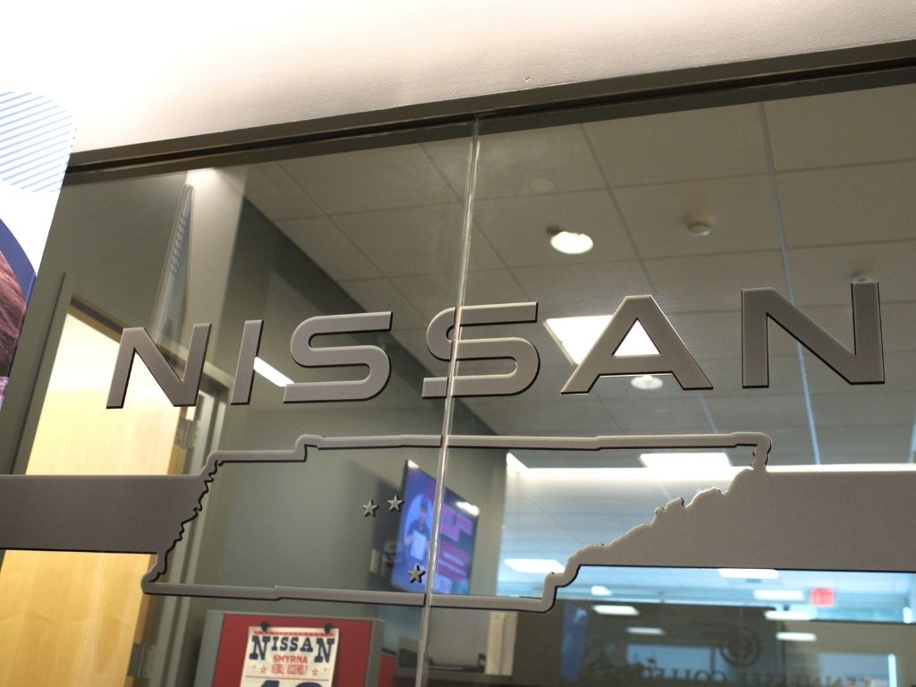A glass wall with the word Nissan on it and an outline of Tennessee